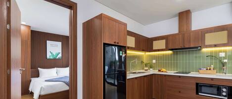 A modern kitchen with wooden cabinets, a black refrigerator, and a microwave.