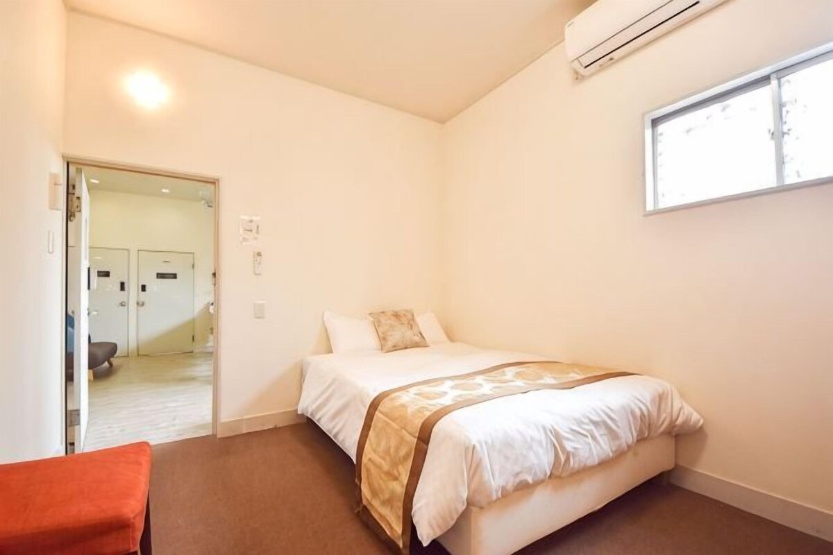 Un dormitorio con cama, ventana y puerta que da a un baño.