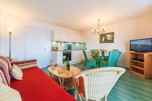 A compact living space with a kitchenette, dining area, and a television.