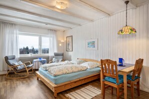 Een gezellige slaapkamer met een houten bed, een eettafel en een stoel.