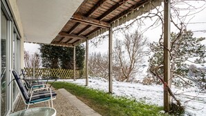 A covered outdoor seating area with chairs and a table, a wooden pergola, and a snow-covered landscape with trees. - Holiday Apartment "Adlerhorst" with Mountain View, Private Terrace & Wi-Fi (Wangen)