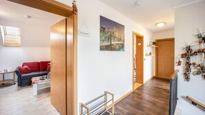 A modern living room with a sofa, a coffee table, and a painting of a cityscape. - Holiday Apartment in the Countryside with Mountain View, Balcony and Wi-Fi (Wolpertswende)