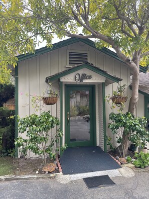 A small building with a green door and the word "Office" above it. - Single Queen Cottage (Carmel-by-the-Sea)