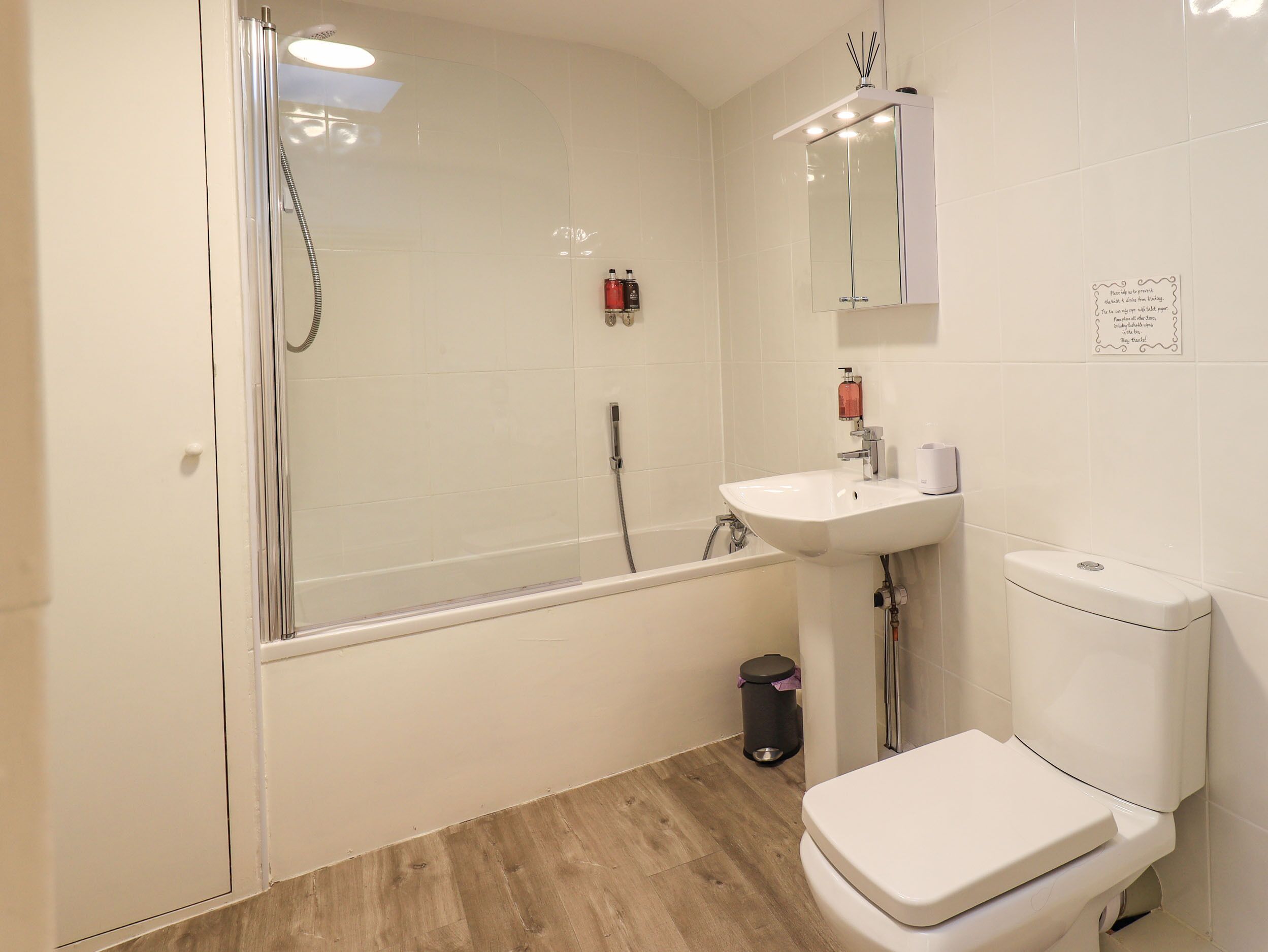 Une salle de bain moderne avec une douche à parois de verre, un lavabo blanc et des toilettes.