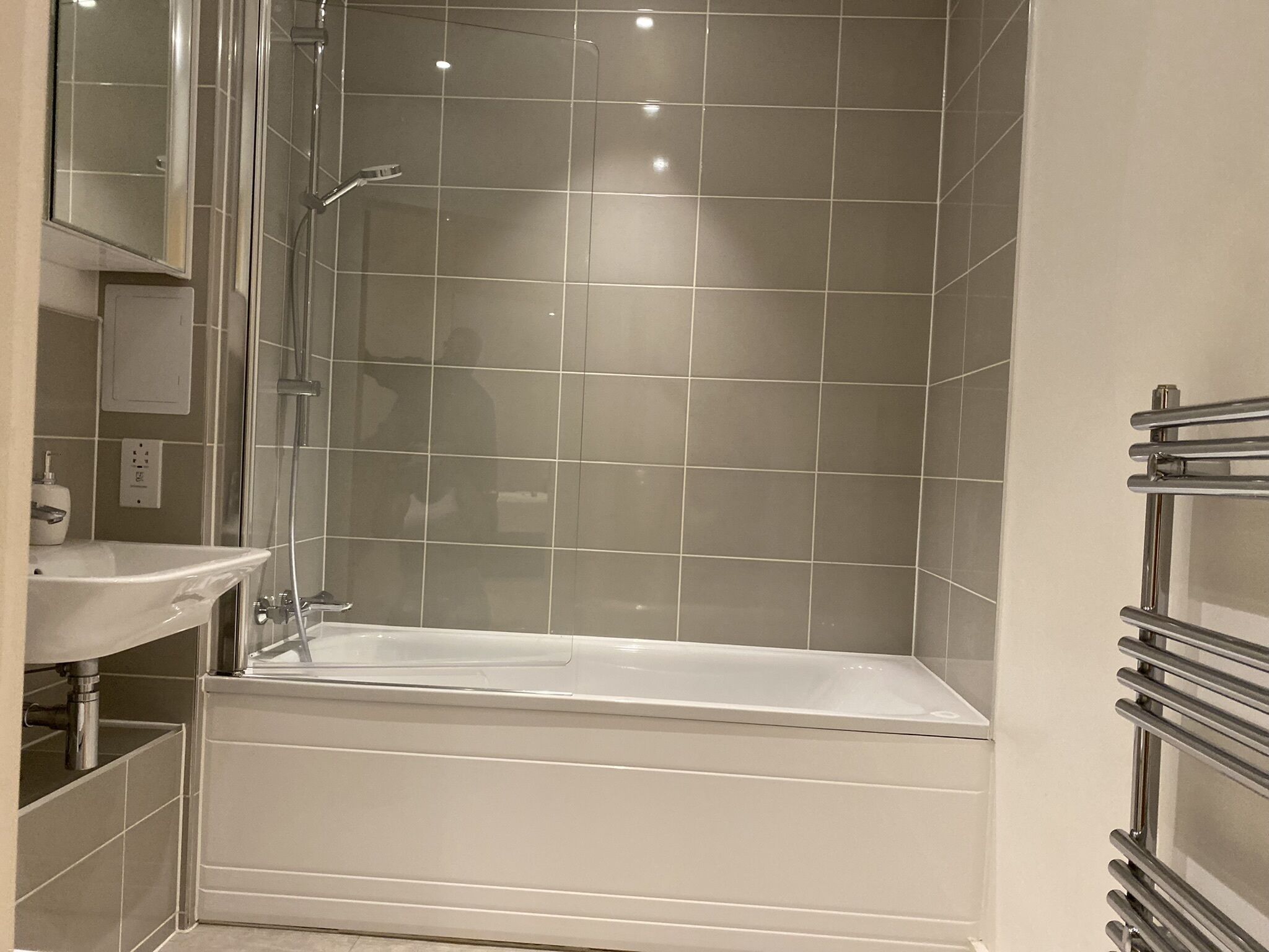 A modern bathroom with a bathtub, a sink, and a mirror.