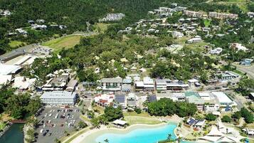 An aerial view of a residential area with multiple buildings, roads, and a swimming pool.