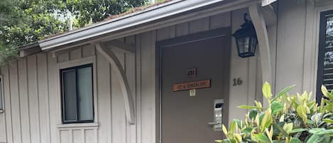 A small, single-story building with a wooden exterior, a door labeled "1st & Guadalupe," and a small window.
