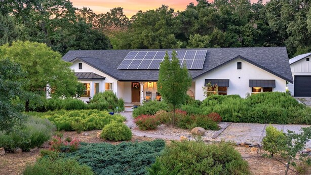 A modern house with solar panels, surrounded by lush greenery and a well-maintained garden. - Château Vigne: Luxe retreat, Hot Tub, plunge pool, Outdoor movies, game room, EV (Atascadero)