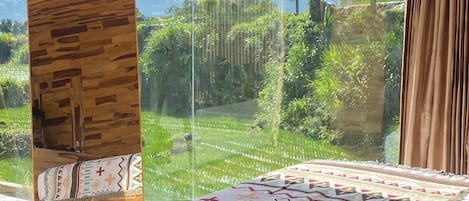 Habitación de cabaña de madera con un ventanal grande que da a un paisaje exuberante.