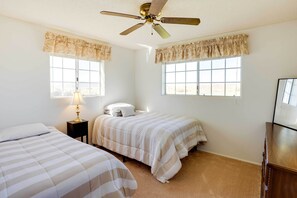 A bedroom with two beds, a ceiling fan, a nightstand with a lamp, and a dresser. - Cortez Retreat w/ Office & Stunning Mtn Views (Cortez)