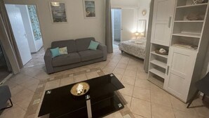 Un salon avec un canapé, une table basse et une armoire.