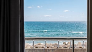 A view of the ocean through a window with a metal railing and concrete blocks. - Sokcho Bird Island Pension (Sokcho)