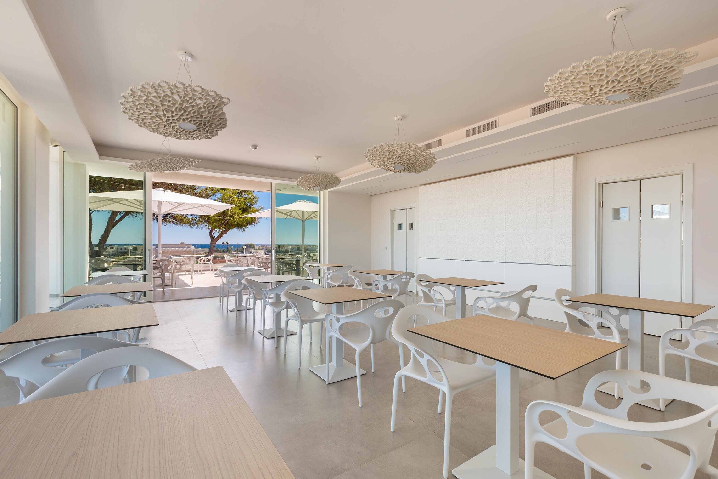 Un aula moderna con mobiliario blanco y ventanas amplias con vistas panorámicas.