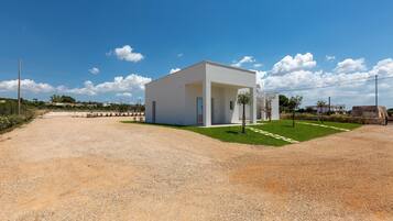Un bâtiment moderne, de plain-pied, doté d’un toit plat, d’une allée gravillonnée et d’une pelouse bien entretenue.