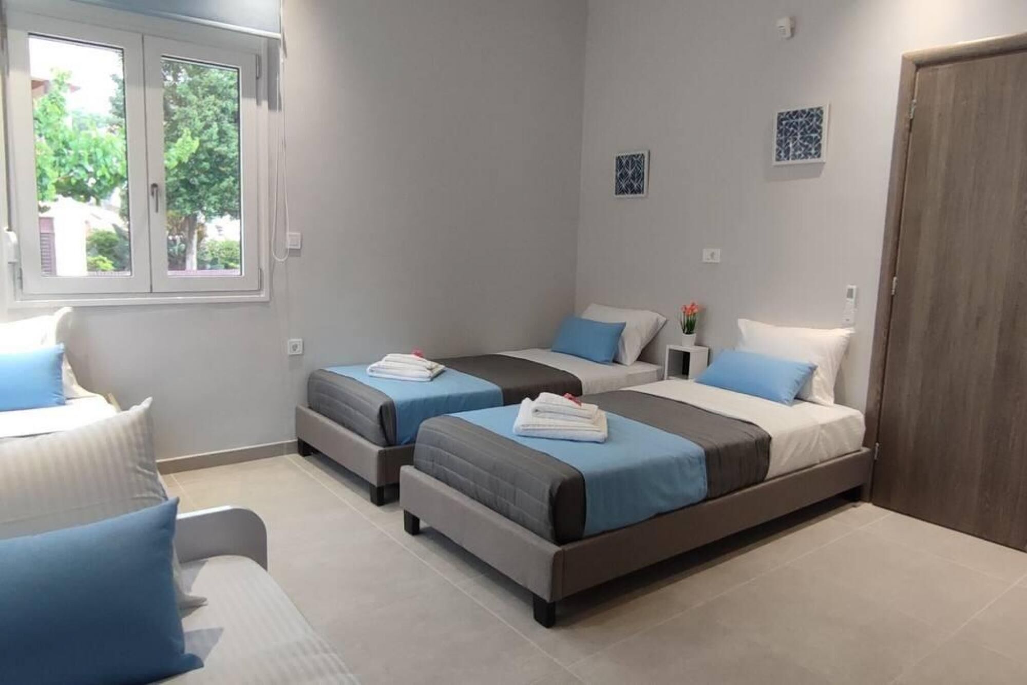 A room with two beds, a chair, and a window.