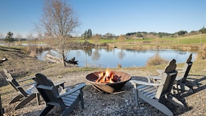 Un cadre idyllique au bord du lac, avec un foyer et des fauteuils Adirondack.