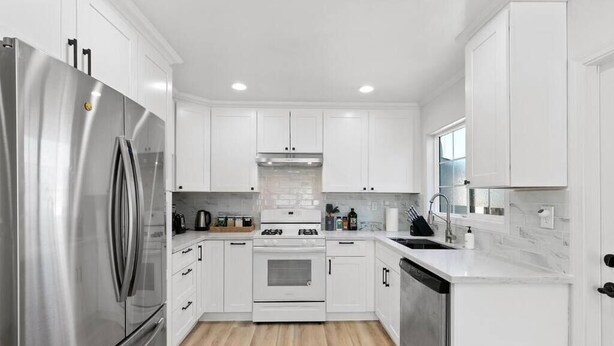 A modern kitchen with white cabinets, stainless steel appliances, and a marble countertop. - Bright & Peace 3BR, RWC Fresh Remodeled & Spotless (Redwood City)