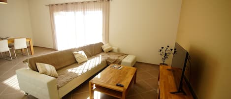 Ein Wohnzimmer mit Sofa, Couchtisch und TV-Schrank.