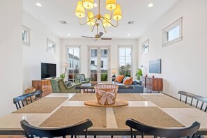 A spacious dining area with a large table, chairs, and a chandelier. - Family Perfect Point Home |  Luxury at its Best (New Orleans)