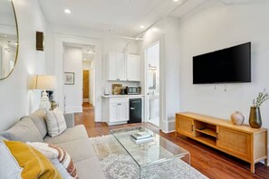 A modern living room with a sofa, coffee table, and a flat-screen TV.