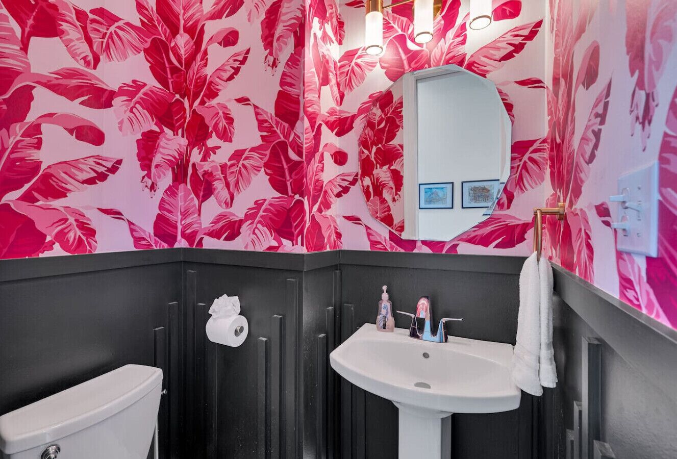 Ein Badezimmer in Schwarzweiß mit einem weißen Waschbecken und einer Toilette.