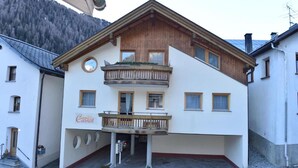 A two-story building with a balcony on the upper floor, a sign reading "Carrot," and a mountainous backdrop. - Retreat in Samnaun Alps (Samnaun)