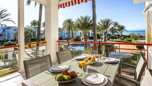 A dining table set for two with a view of a pool and palm trees. - L'Alberca by Interhome (Dénia)