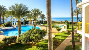 A resort with a swimming pool, palm trees, and a view of the ocean. - L'Alberca by Interhome (Dénia)