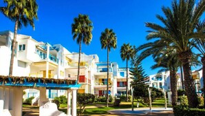 A resort with multiple-story buildings, palm trees, and a paved walkway. - L'Alberca by Interhome (Dénia)