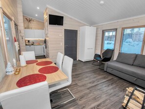 A modern interior with a dining area, a sofa, and a kitchen. - Adeli holiday cottage ellivuori by Interhome (Sastamala)