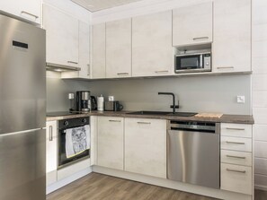 Una cocina moderna con electrodomésticos de acero inoxidable, un microondas y un lavavajillas.
