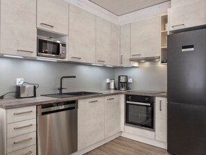 Eine moderne Küche mit Edelstahlgeräten, einem Geschirrspüler und einem Kühlschrank.