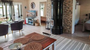 A cozy living room with a fireplace, wooden furniture, and a television. - Kivilahti vuokatti by Interhome (Sotkamo)