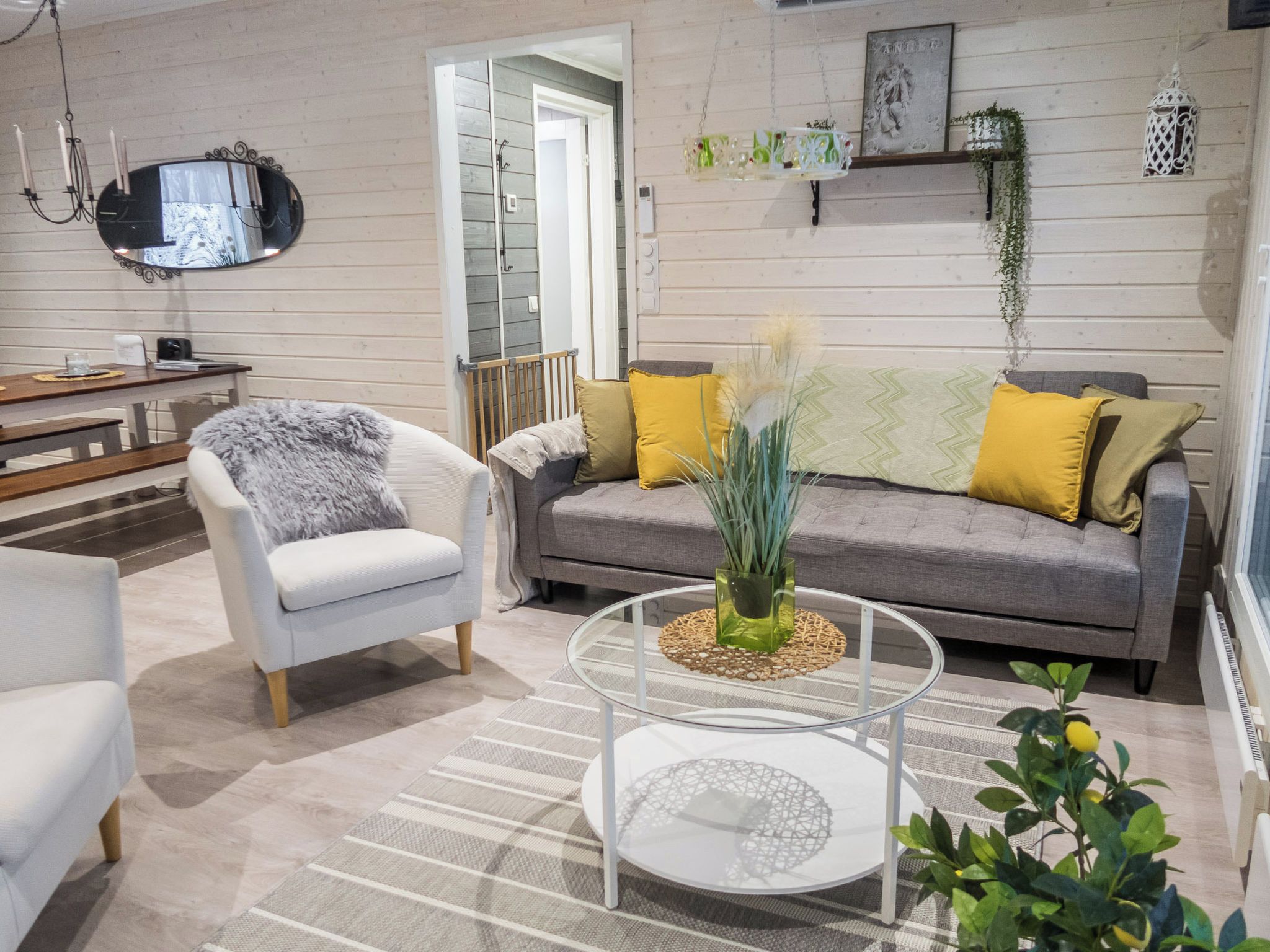 Una sala de estar moderna con un sofá, un sillón y una mesa de centro de vidrio.