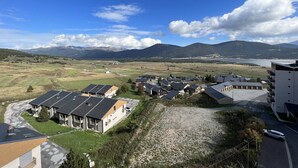 Un barrio residencial con casas modernas, un camino de grava y vistas a montañas y un lago.