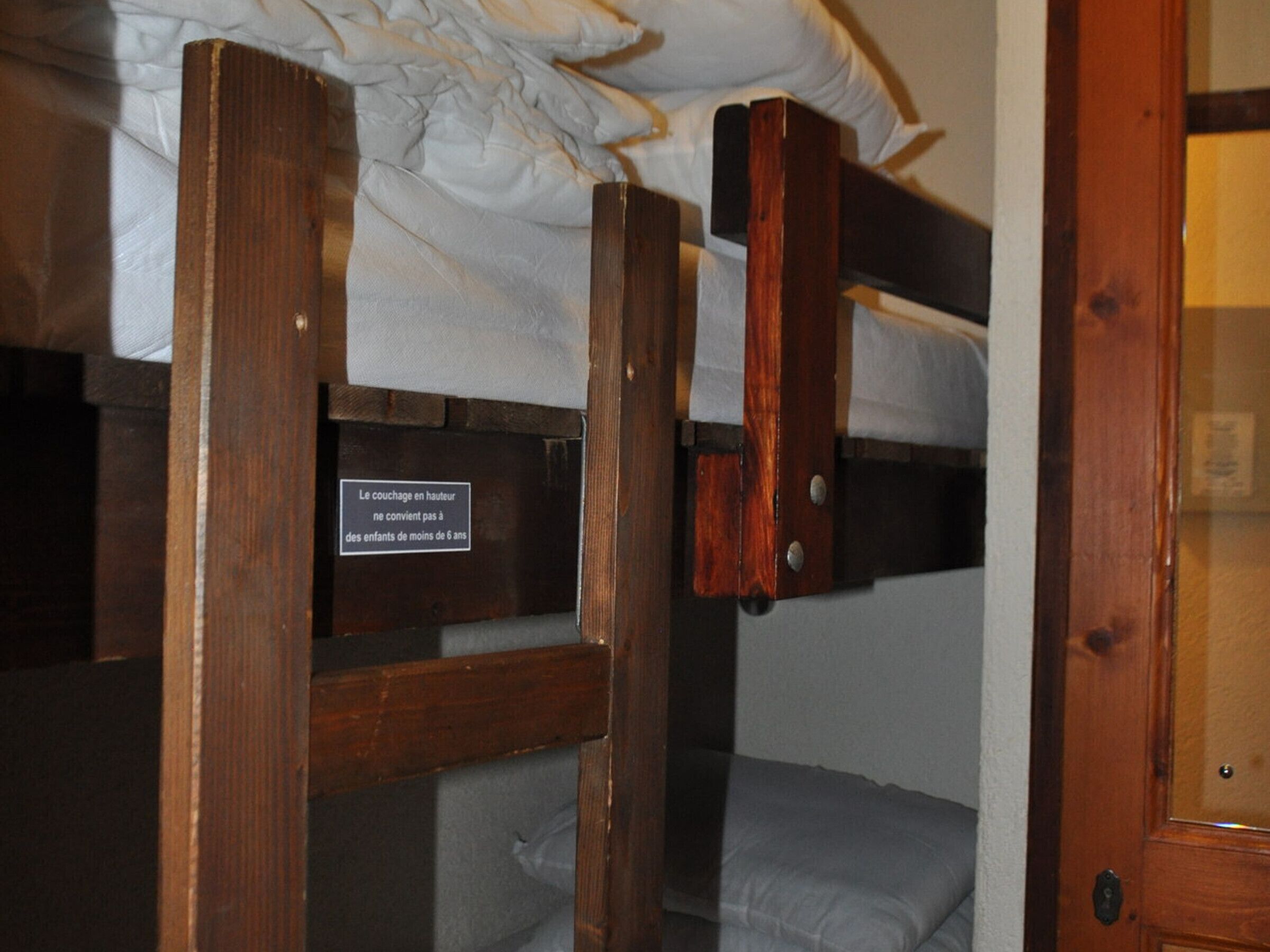 A bunk bed with a sign indicating it is not suitable for children under 6 years old.