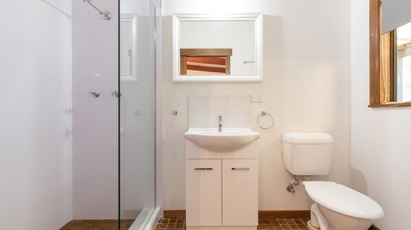 A bathroom with a glass shower enclosure, a white sink, and a toilet. - Tarbuck Cabin relax and enjoy a fuse free holiday (Tarbuck Bay)