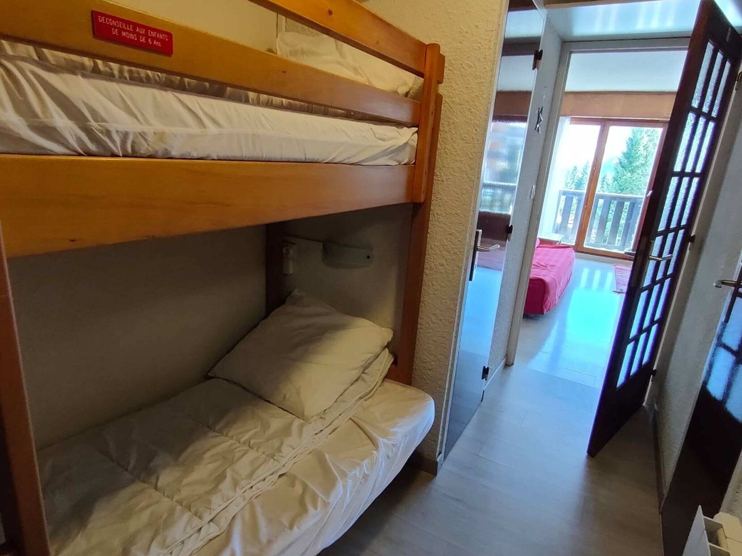 Camera con letti a castello e cartello che indica che è adatta a bambini di età inferiore ai 5 anni.