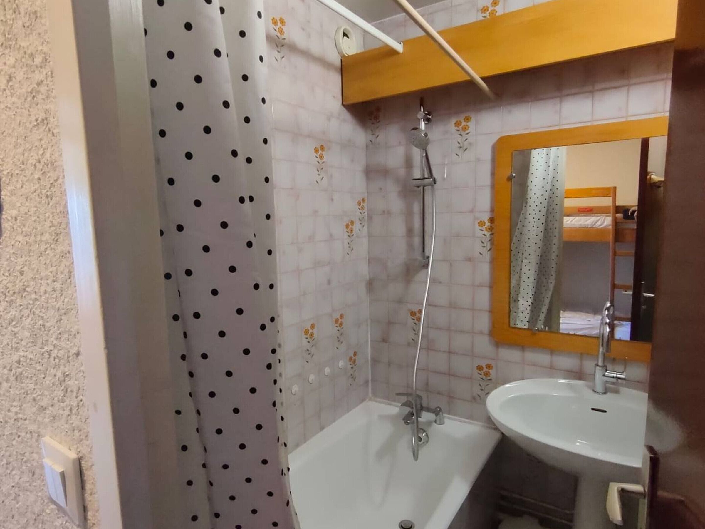 Ein Badezimmer mit Dusche, Waschbecken und Spiegel.