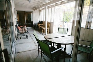 Enjoy meals and relaxation in this room with a central dining table and comfortable seating area leading out to an outdoor space.