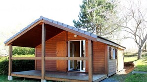 A wooden cabin with a covered porch and a large sliding glass door.