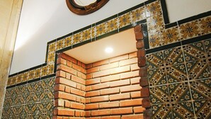 Une cheminée d’angle avec un mur en briques et des carreaux décoratifs.