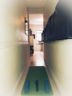 Exercise and refresh in this serene hallway, featuring a yoga mat and foam rollers.