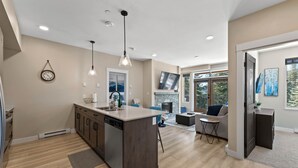 Cocina moderna con isla central, lavavajillas integrado e iluminación colgante.