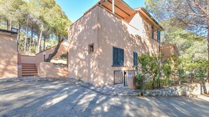 A building with a stone pathway leading to a gated entrance, surrounded by trees. - Holiday Apartment 'Il Papavero' with Wi-Fi (procchio)