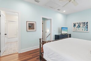 Une chambre à coucher avec un grand lit, une télévision et des œuvres d’art accrochées aux murs.