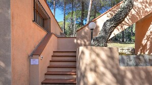 Una escalera conduce a la entrada de un edificio, con piso de baldosas de piedra y un cartel que indica un espacio público.