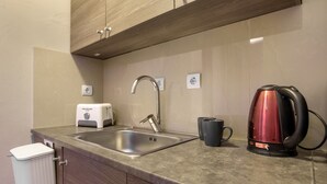 Una cucina con lavello, tostapane, bollitore e mobile.