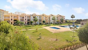 A residential building with multiple balconies, a swimming pool, and a well-maintained lawn. - Apartment "Columbus Beach" with Sea View, Shared Pool & Wi-Fi (Quarteira)