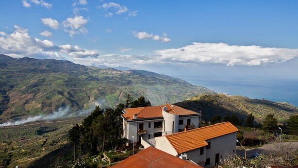 A coastal view with a house featuring a red-tiled roof, surrounded by greenery and mountains. - Holiday Home 'Paese Albergo - Arconides' with Sea View, Balcony and Wi-Fi (Motta D'affermo)